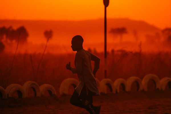 Fit person exercising outdoor with sunset background.